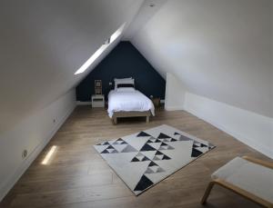a attic bedroom with a bed and a rug at Gite Kalon in Pouldreuzic