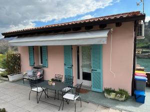 a pink house with a table and chairs on a patio at @LaCasettasulFiume in Sarnico