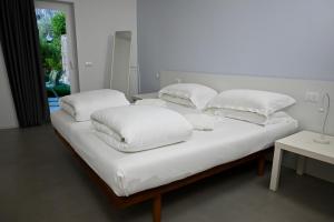 a bed with white sheets and pillows on it at Appartamenti Villa al Fiume in Nago-Torbole