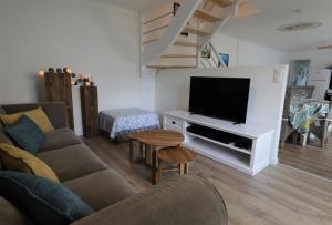 a living room with a couch and a flat screen tv at Gite Kalon in Pouldreuzic