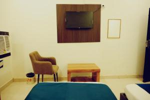 a bedroom with a bed and a tv and a table at Hotel Shyam Palace Near Kapurthala Mahanagar Lucknow in Lucknow