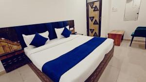 a bedroom with a large bed with blue pillows at Hotel Shyam Palace Near Kapurthala Mahanagar Lucknow in Lucknow