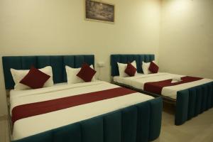 two beds in a hotel room with red and white at Hotel Shyam Palace Near Kapurthala Mahanagar Lucknow in Lucknow +13 photos