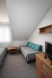 a room with a bed and a tv and a table at Kalipso nad Jeziorem Białym in Okuninka