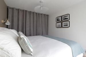 a bedroom with a bed with white sheets and pillows at Gite Kalon in Pouldreuzic +5 photos