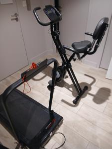 a black exercise bike and a chair in a room at Chezgege in Valloire