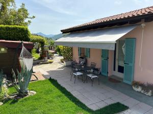 a patio with a table and chairs and a house at @LaCasettasulFiume in Sarnico