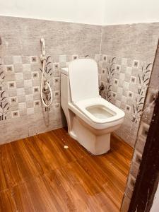 a bathroom with a toilet and a phone on the wall at BTS STAY- Singh Niwas in Ghaziabad +5 photos
