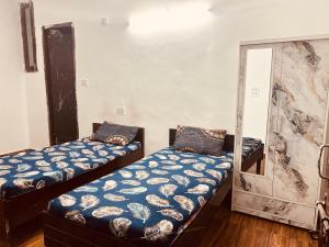 a room with two beds and a mirror at BTS STAY- Singh Niwas in Ghaziabad
