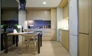 a kitchen with a table and a refrigerator at Sfera Residence Kuala Lumpur City Centre in Kuala Lumpur