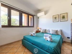 a bedroom with a blue bed with towels on it at Estay - Carrubo Oasis - Swimming pool & Garden in Pula