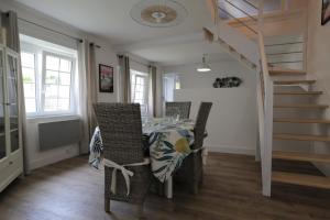 a dining room with a table and chairs and a staircase at Gite Kalon in Pouldreuzic