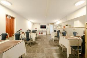 a dining room with tables and chairs and a tv at A25 Hotel - 46 Châu Long in Hanoi