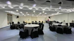 a banquet hall with white tables and black chairs at BIDONG VIEW RESORT in Kuala Terengganu +112 photos
