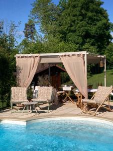 a gazebo and chairs next to a swimming pool at Escale sur la Côte in Porrentruy