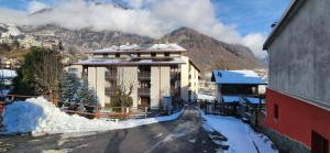 a house in the snow with a mountain in the background at Valmalenco Home in Chiesa in Valmalenco
