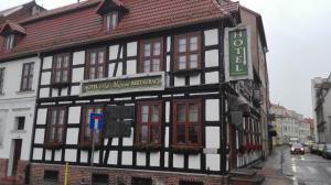 ein schwarz-weißes Gebäude an der Ecke einer Straße in der Unterkunft Noclegi pod Muzami in Cammin in Pommern