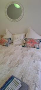 a bed with pillows and a mirror on the wall at Šiauliai Central Vytauto Apartment in Šiauliai