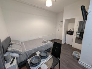 a small room with a bed and a table at Tredegar Arms Budget Guesthouse For Walkers/Cyclists/Contractors/Traveler in Merthyr Tydfil