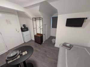 a living room with a table and a tv on the wall at Tredegar Arms Budget Guesthouse For Walkers/Cyclists/Contractors/Traveler in Merthyr Tydfil
