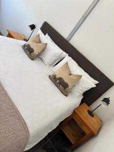 ein Bett mit weißen Laken und Kissen sowie zwei Lampen in der Unterkunft Riverview Rest in Addo