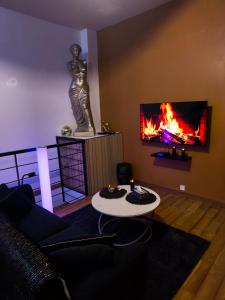 a living room with a statue and a fire in the wall at Loveroom LovaLova in Reims
