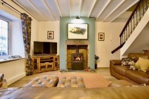 a living room with a couch and a fireplace at Millside Cottage in Braithwaite