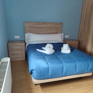 two stuffed animals sitting on top of a bed at Pensión Palomos in San Xoán de Río +3 photos