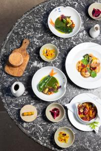 a table with white plates of food on it at La Bastide De Moustiers - Hôtel et Restaurant - Teritoria in Moustiers-Sainte-Marie