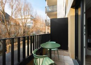 a balcony with a green table and two chairs at Limehome Mannheim City Center in Mannheim