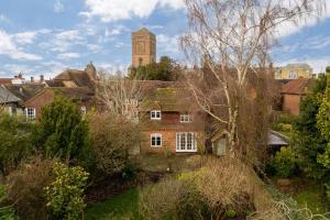 an old house with a clock tower in a village at The Nook by The Butler Collection in Petworth