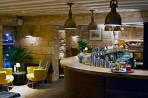 a bar in a restaurant with yellow chairs at Dormy House Hotel in Broadway