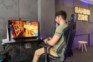 a man sitting in a chair playing a video game at Cambrils Paradise in Cambrils