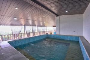 a large swimming pool in a building with a balcony at Hotel Padma in Morjim