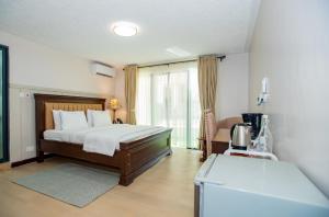 a bedroom with a bed and a large window at Cozy Stead Hotel - Haven House, Gigiri in Nairobi