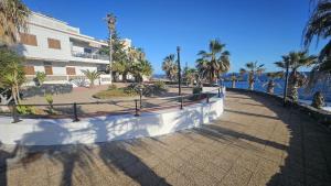 a walkway next to a building next to the water at La Perlita in Las Eras
