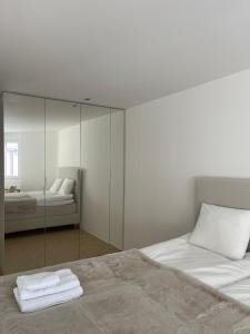 a bedroom with two beds and a mirror at Wasserfall - Zentrum - Balkon - Seeblick - Küche in St. Moritz