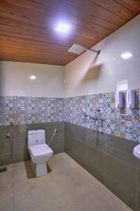 a bathroom with a toilet and a sink at Hotel Padma in Morjim +26 photos