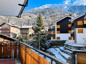 a view from a balcony of a town with snow covered mountains at GuestHost - Il Dente del Gigante in Courmayeur
