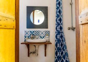 a bathroom with a sink and a mirror at Gecko Cottage - Cosy 2-Bedroom in Bagamoyo Old Town in Bagamoyo