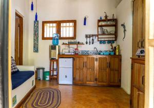 a kitchen with wooden cabinets and a white refrigerator at Gecko Cottage - Cosy 2-Bedroom in Bagamoyo Old Town in Bagamoyo
