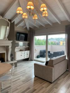 a living room with a couch and a chandelier at Penthouse Apartment Desenzano in Desenzano del Garda