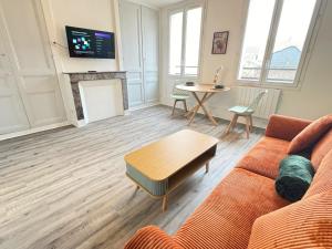 a living room with a couch and a table at L'Escapade Havraise in Le Havre