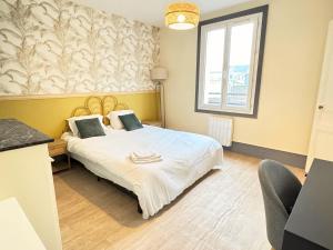 a bedroom with a bed and a desk and a window at L'Escapade Havraise in Le Havre