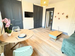 a living room with a table and a couch at L'Escapade Havraise in Le Havre