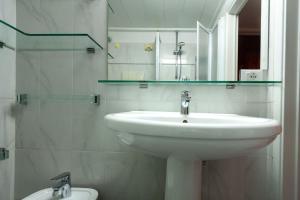 a bathroom with a sink and a mirror and a toilet at Appartamento MO in Follonica +26 photos