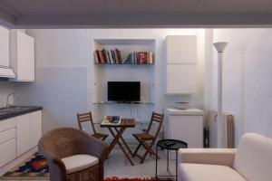 a kitchen with a living room with a table and chairs at Appartamento MO in Follonica