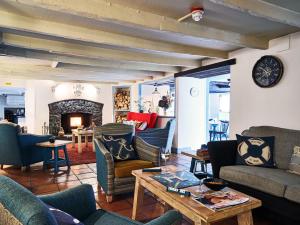 a living room with couches and a table and a fireplace at Lugger Hotel ‘A Bespoke Hotel’ in Portloe