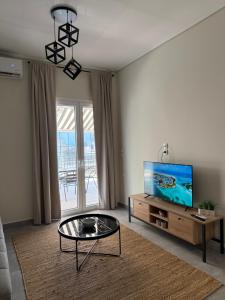 a living room with a tv and a coffee table at Feels Like Home - Agrinio Suites in Agrinio