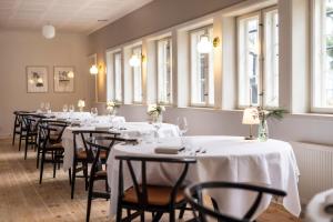 a row of tables in a room with windows at Molskroen in Ebeltoft
